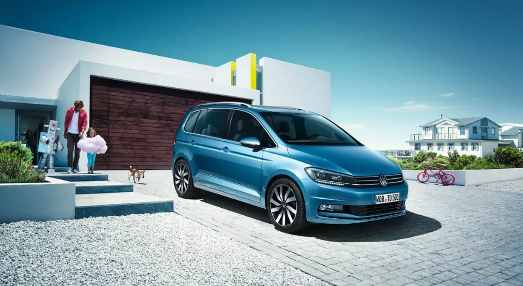 Blå volkswagen parkerad på en utfart