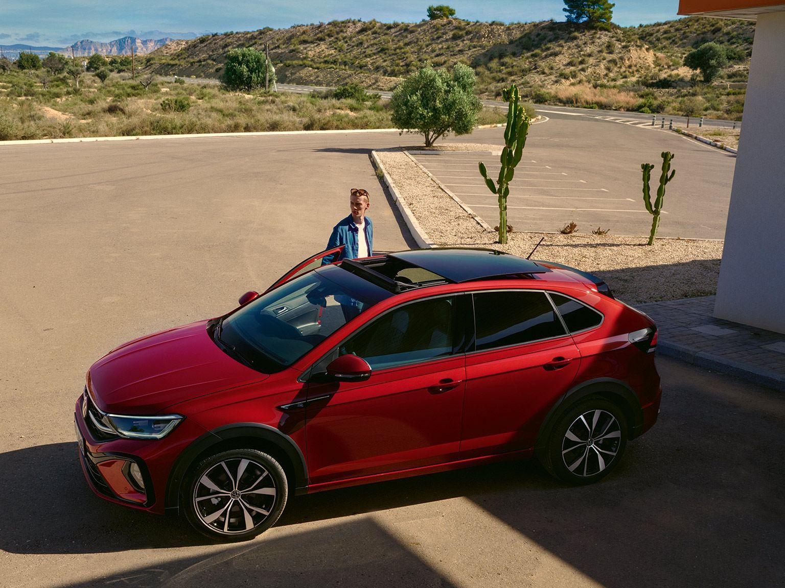 En man står brevid en röd volkswagen