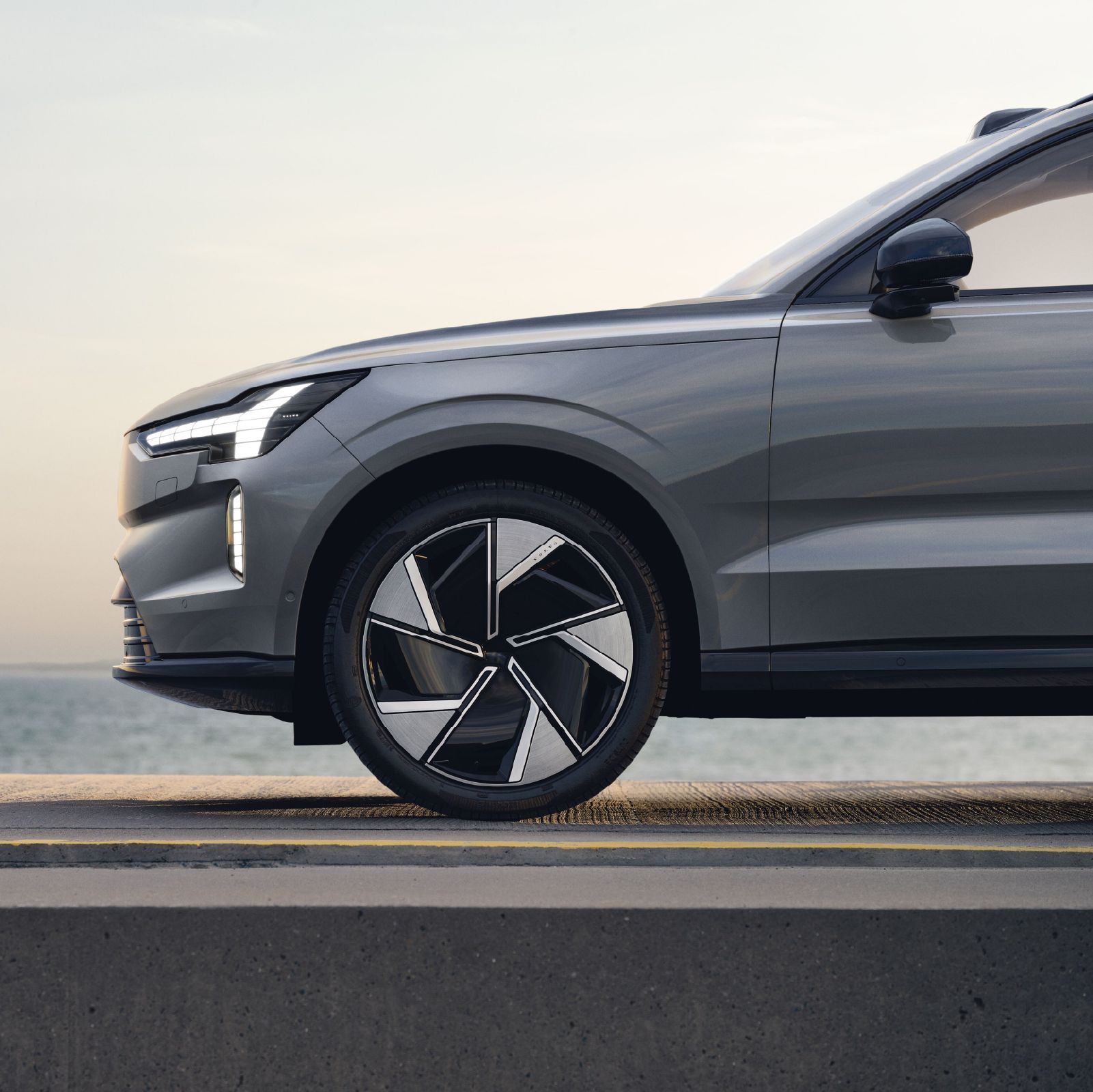 Silvergrå elbil parkerad vid havet