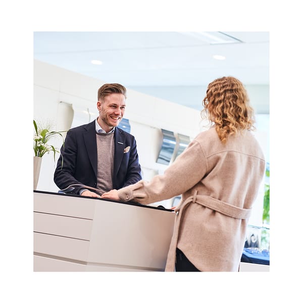 Bilhandlare som hjälper kund med materialval för bil