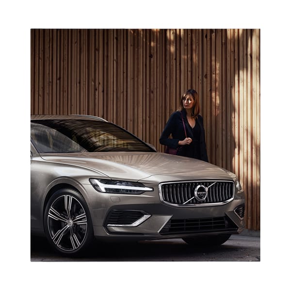 affärskvinna som står bredvid sin volvobil i silverfärg