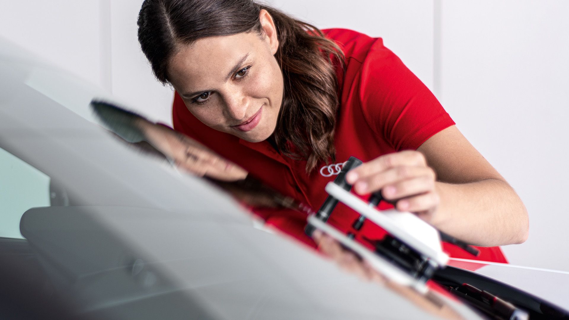 Kvinna putsar fronten av en bil