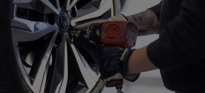 Man som använder maskin för att fixa däcken på en bil i en däckverkstad