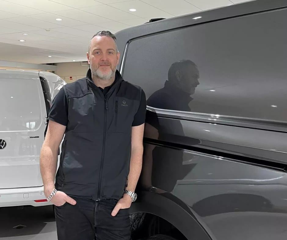 Grå volkswagen transportbil med en kanot på taket