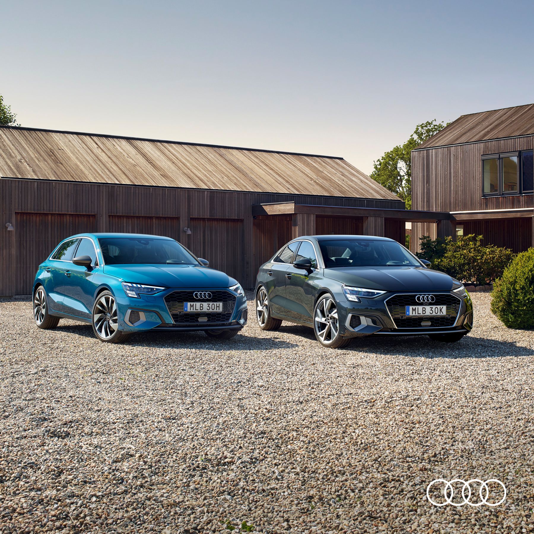 Två olika Audimodeller står brevid varandra parkerade utomhus