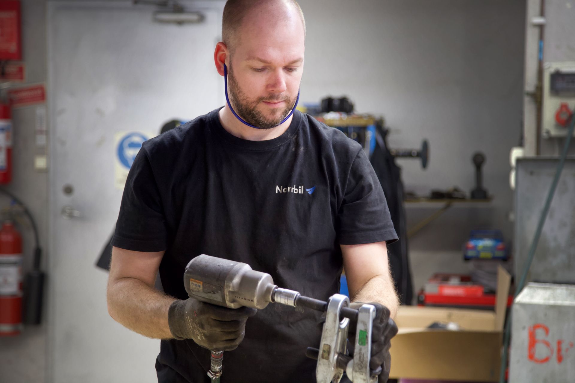 Man utan hår skruvar med en maskin