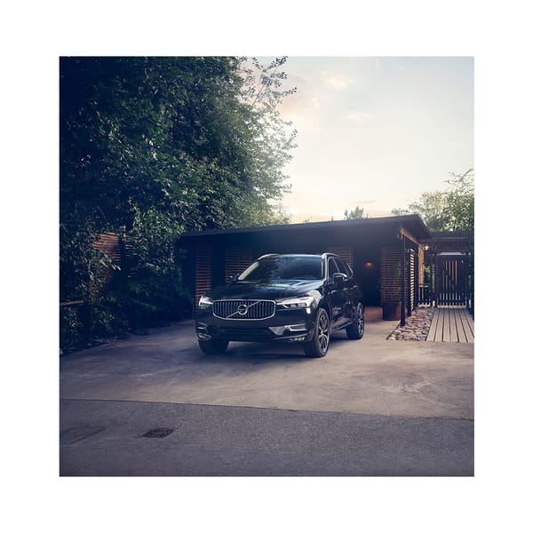 En svart volvo bil parkerad på en uppfart vid ett hus